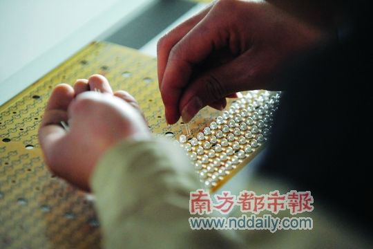 工人忙著安裝用于燈具發(fā)光的LED燈珠，這類工作處于LED燈具生產(chǎn)的最下游。資料圖